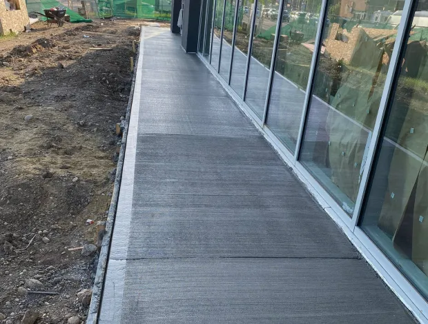 Residential walkway poured beside a home with clean concrete finishing