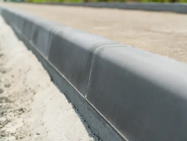 Freshly formed concrete curbing installed along a driveway or landscaped edge